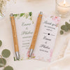 Two personalized engraved bamboo pens rest on a thank you card with floral accents.