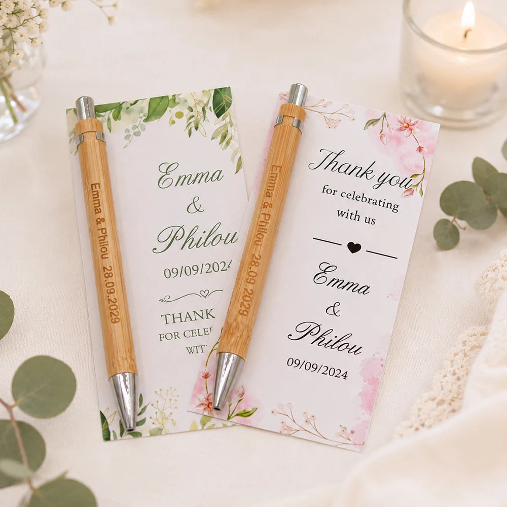 Two personalized engraved bamboo pens rest on a thank you card with floral accents.