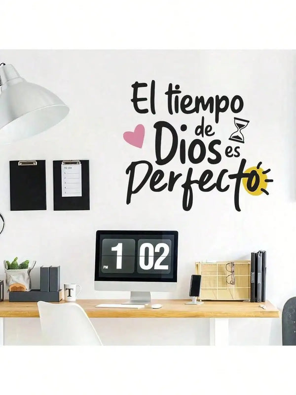 A white wall features a black inspirational quote on a wooden desk above a computer monitor.