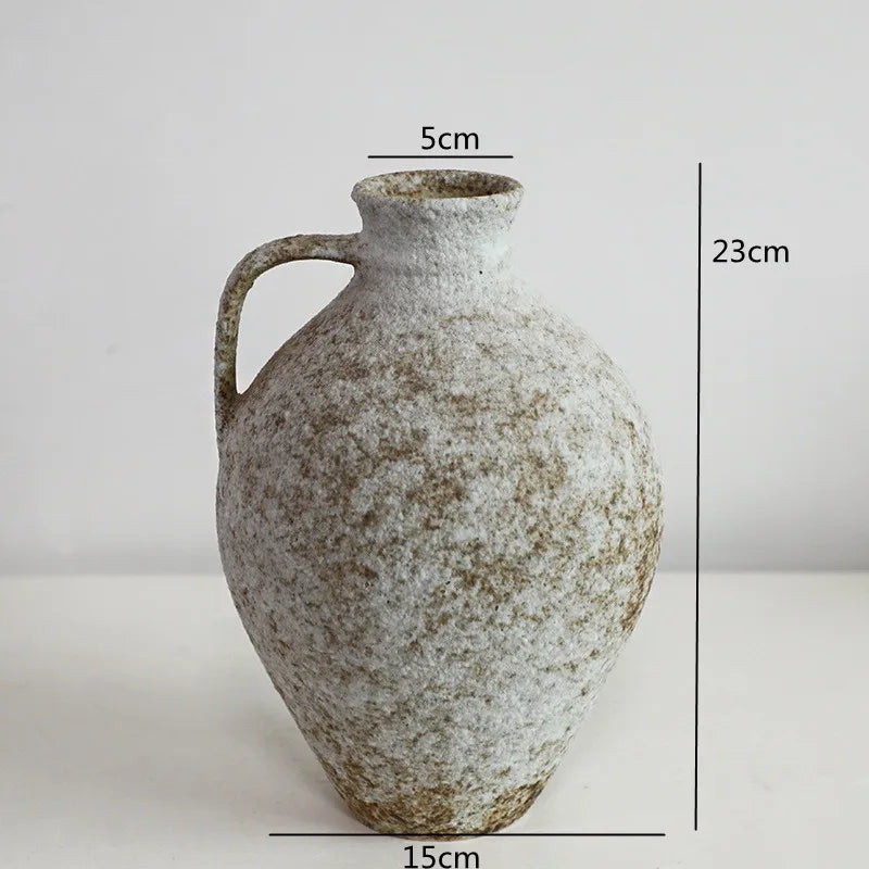 A vintage dual-sided ceramic vase with a rounded body and narrow neck, showing speckled off-white and brown tones.