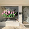 A close-up view of a white vanity countertop with a glass bowl and pink tulip window decals displayed in a bright room.