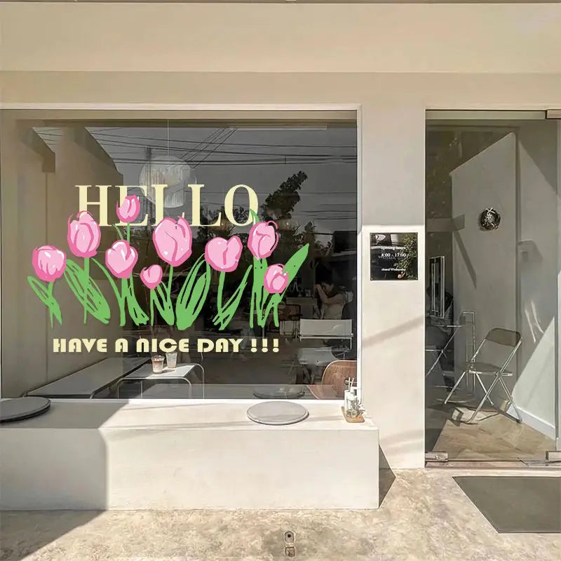 A close-up view of a white vanity countertop with a glass bowl and pink tulip window decals displayed in a bright room.