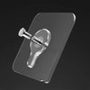 A transparent self-adhesive wall hook with a threaded post is shown against a dark background.