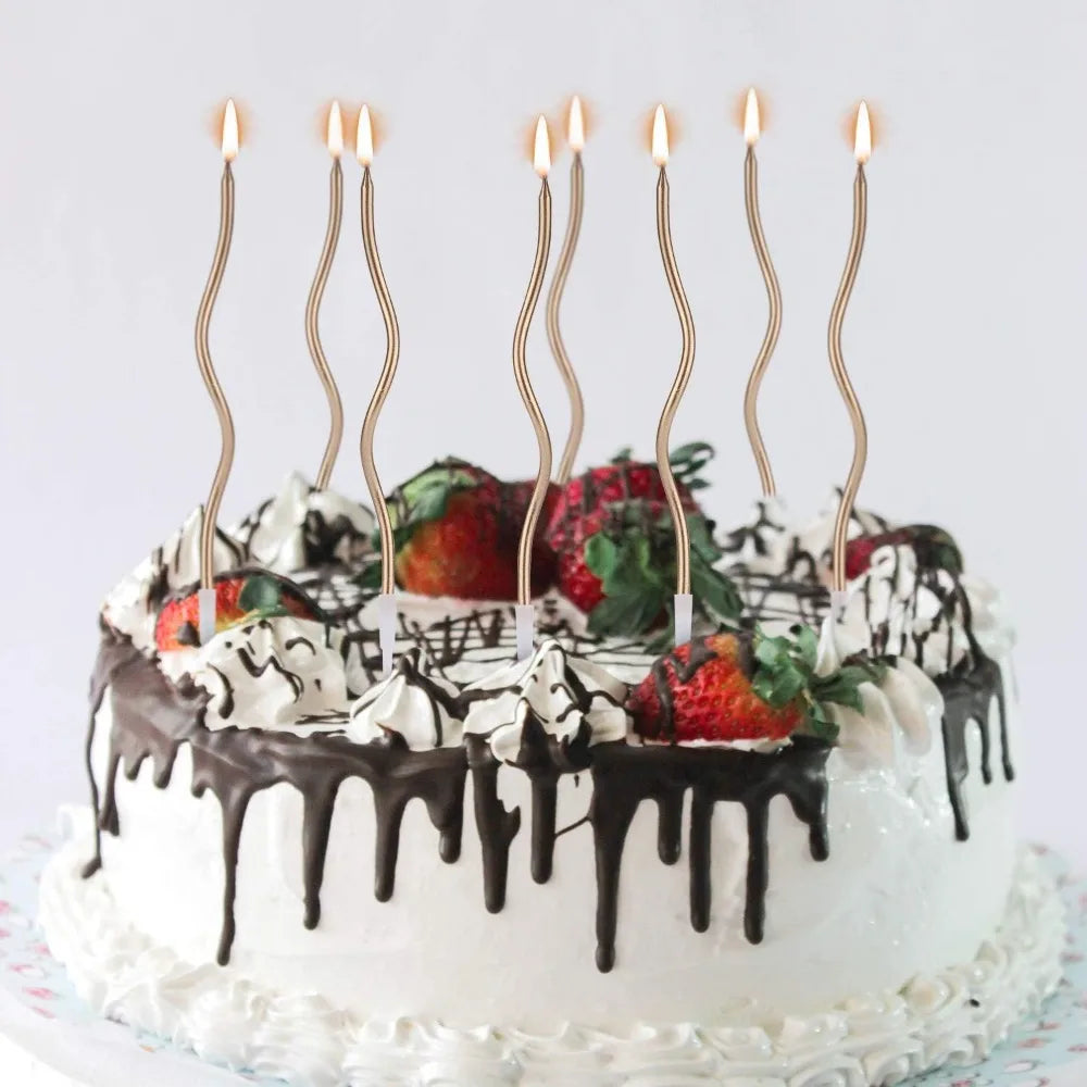 A white cake decorated with chocolate drip and cream frosting, topped with several tall, thin candles.