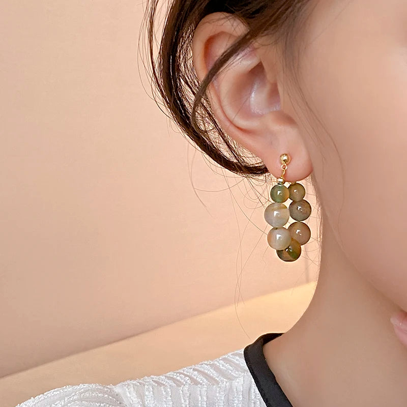Gold-toned resin beaded drop earrings with light green and olive colored beads