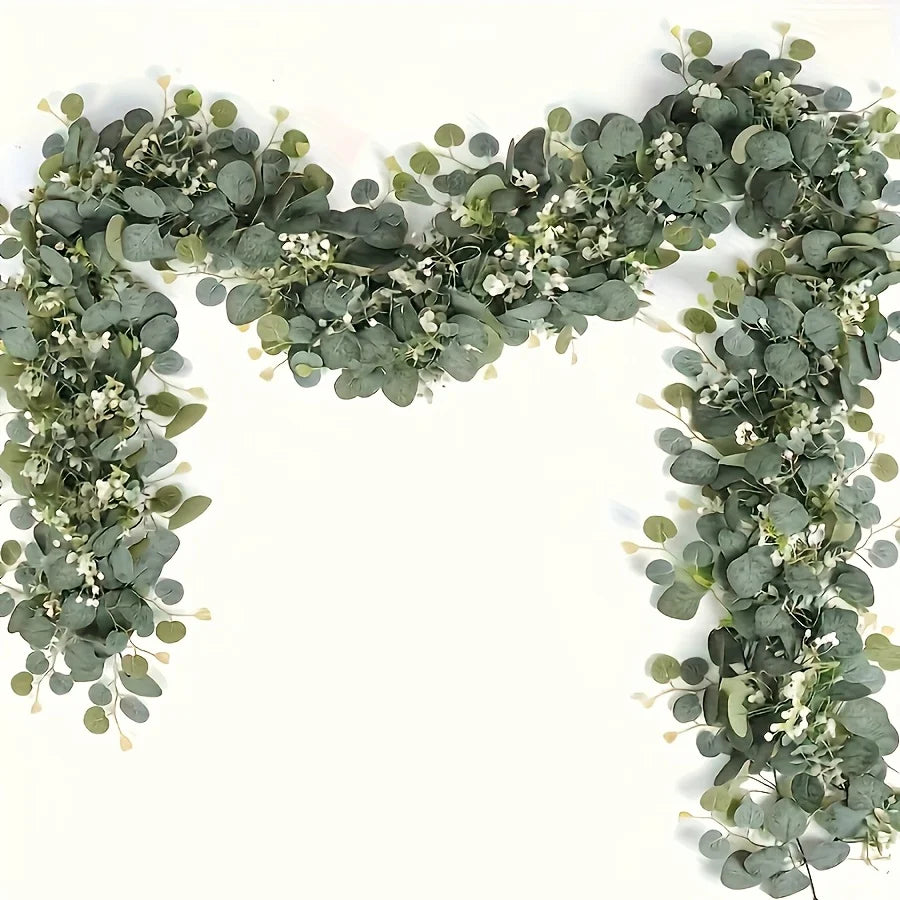 A horizontal garland of silvery-green eucalyptus leaves and small white flowers forming a decorative arch.