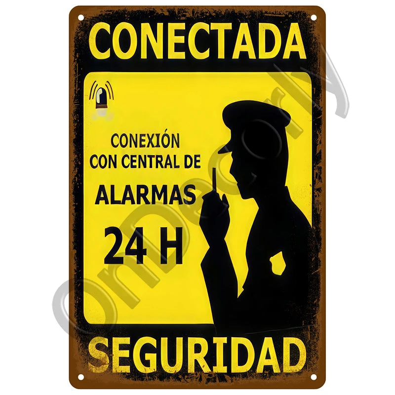 Vintage metal sign with yellow and black text warning about a connected alarm system for 24-hour security.