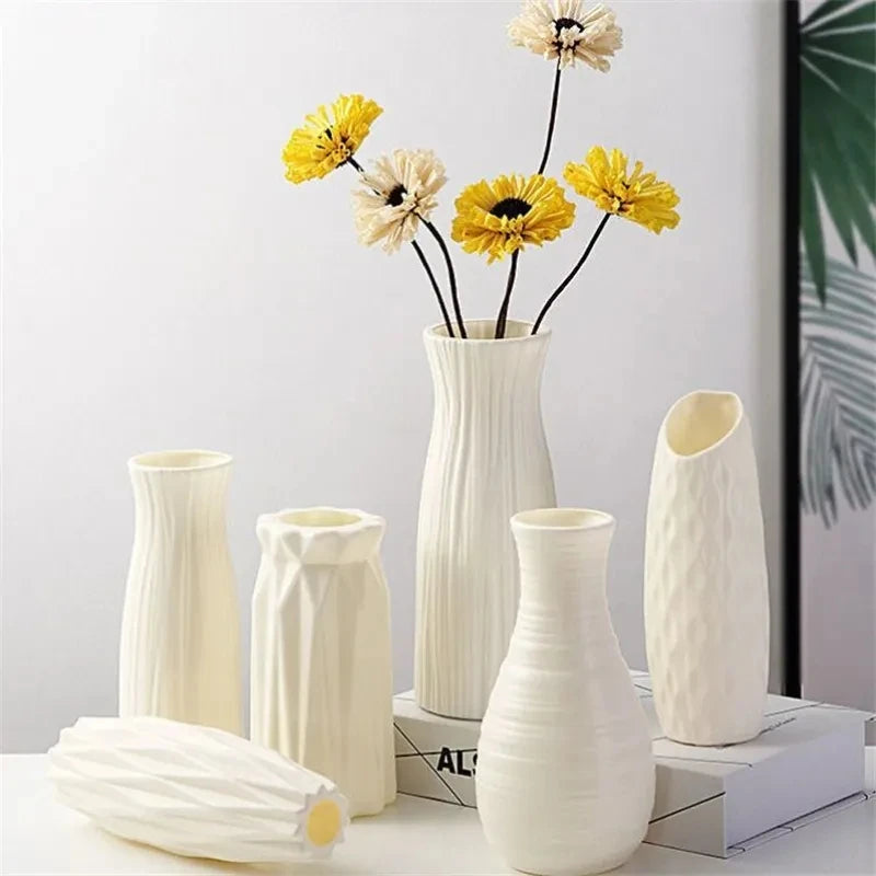A collection of white Nordic minimalist plastic vases of varying heights and shapes for fresh flowers.