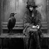 A dark academia witch demon art canvas print featuring a woman in a hooded cloak sitting on a wooden bench with a raven.