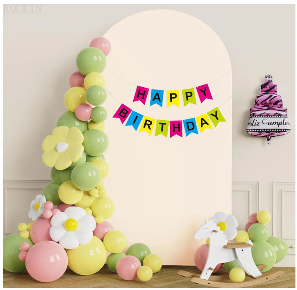 Arreglo floral vertical de globos rosas y verdes con una pancarta de cumpleaños feliz contra una pared clara.