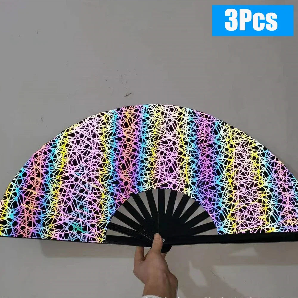 Three folding bamboo hand fans with a colorful geometric pattern displayed against a white wall.