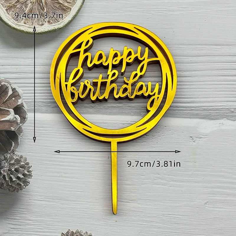 A gold acrylic birthday cake topper with the words Happy Birthday on a stick, set against a light wooden background.