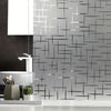 A close-up of frosted electrostatic window film applied to glass, featuring a geometric pattern on a kitchen backsplash.
