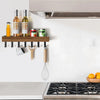 Rustic wooden floating shelf with hooks displaying olive oils and a whisk above a stovetop.