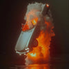 A white race car is engulfed in flames and smoke, reflected on dark water.