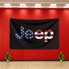 A black flag banner featuring the Jeep logo with an American flag design on a red wall.