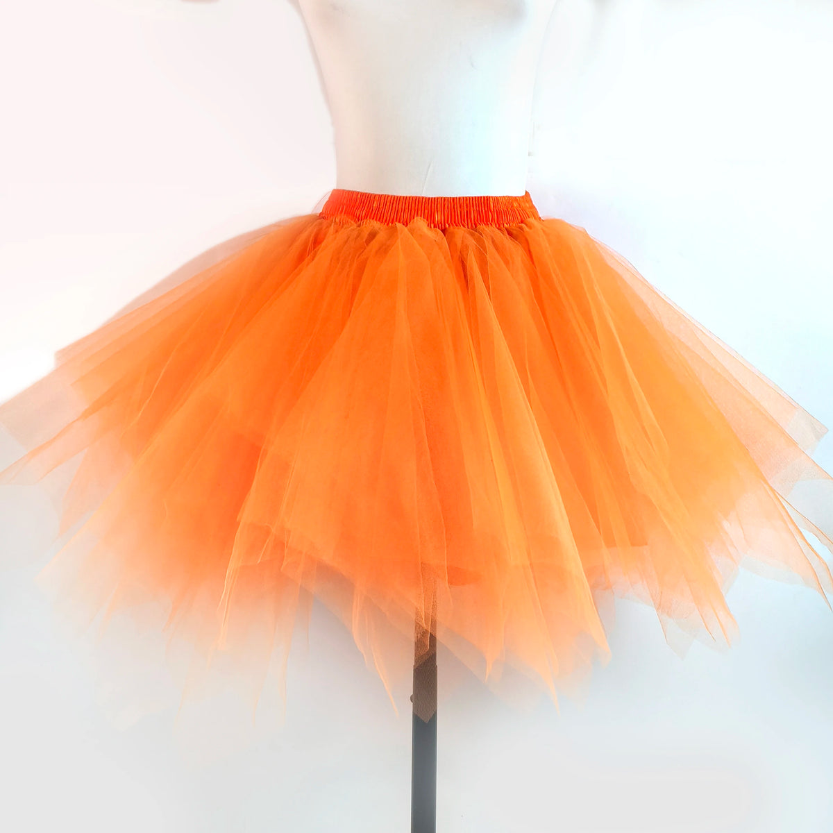Orange tulle tutu skirt displayed on a white mannequin.