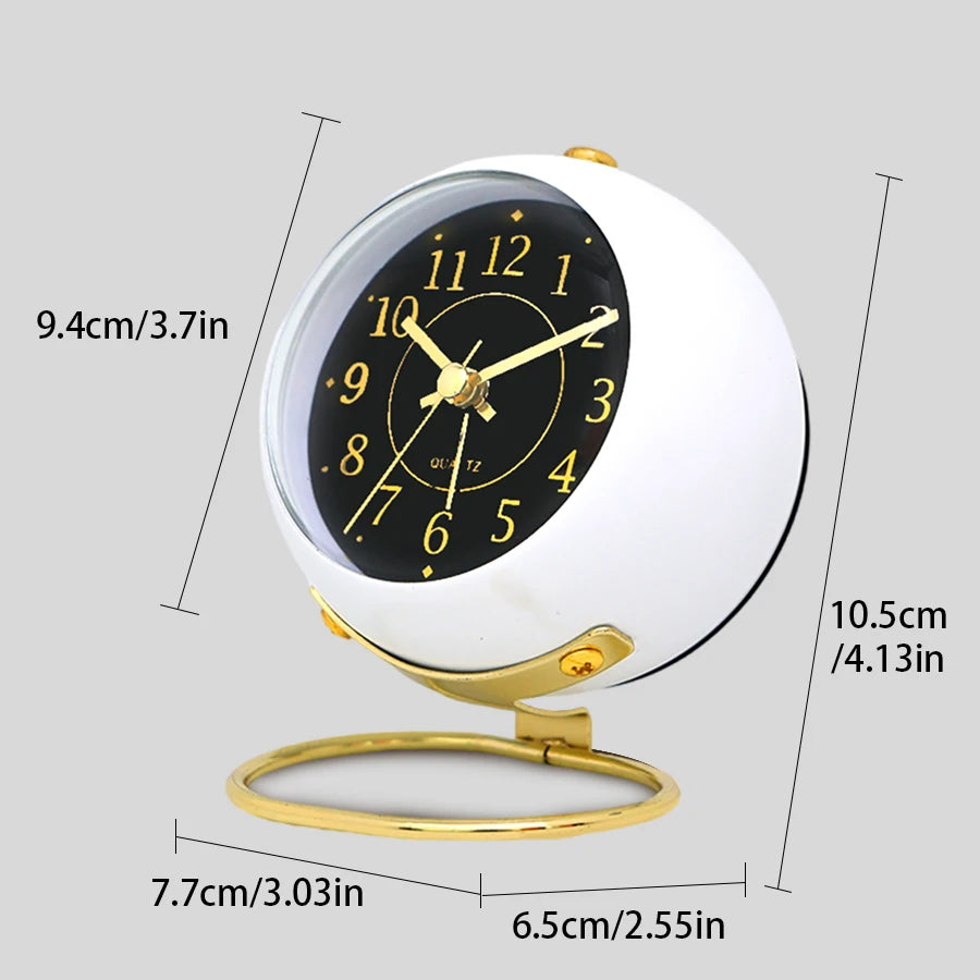 A white minimalist Nordic alarm clock with a black face and gold accents, shown from above.