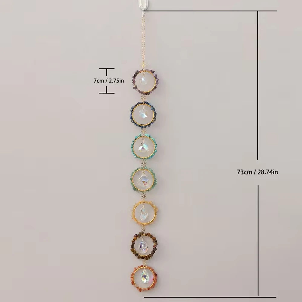 A set of nine crystal suncatchers hanging vertically against a light background.