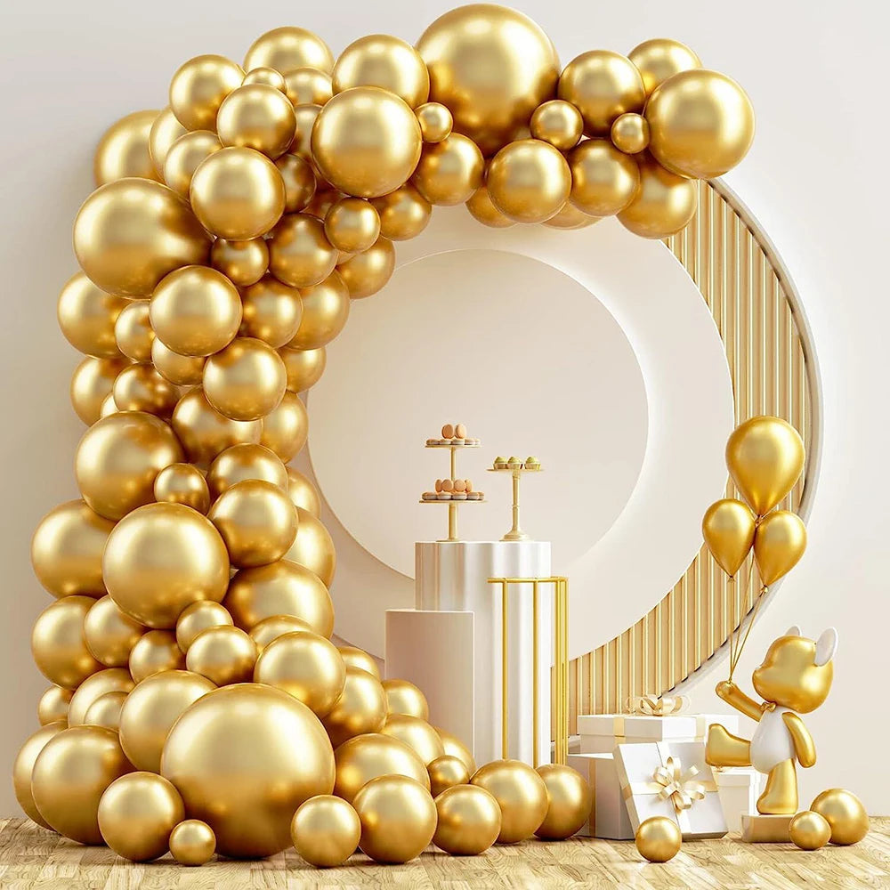 A large arrangement of metallic gold balloons forming an arch shape on a wooden surface.