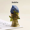 A natural crystal sodalite stone is mounted on a brass bell with a copper finish.