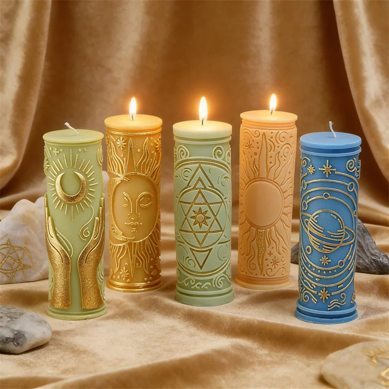 Five pillar candles in various colors glow on a golden fabric with celestial and mystical symbols.
