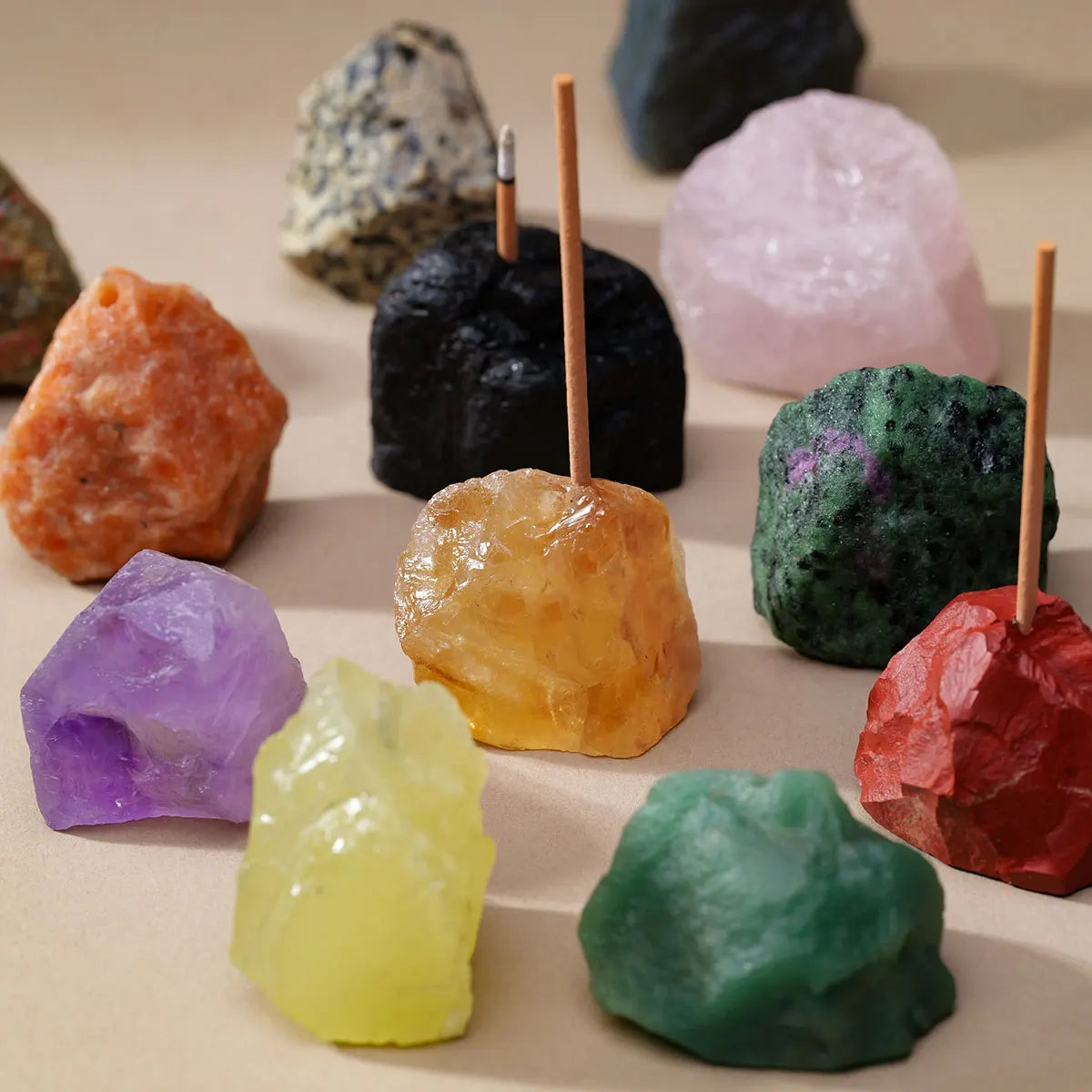 A collection of natural amethyst and clear quartz crystals displayed on a light background with wooden holders.