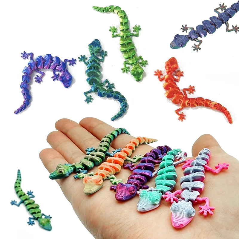 A hand holds several colorful 3D printed articulated gecko desk toys in various poses and colors.