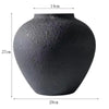 A dark gray rustic textured round vase with dimensions 14cm high and 29cm wide.