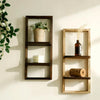 A rustic wooden floating shelf with two tiers displaying a potted plant and a glass bottle on a light-colored wall.