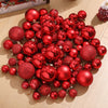 A collection of assorted shiny red and gold Christmas tree ornaments and pendants scattered on a light wooden surface.