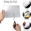 A hand is shown cutting a flexible, reflective, self-adhesive acrylic mirror wall sticker.
