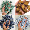 A collection of natural raw healing crystal stones in various shades of green and blue are held in hands.