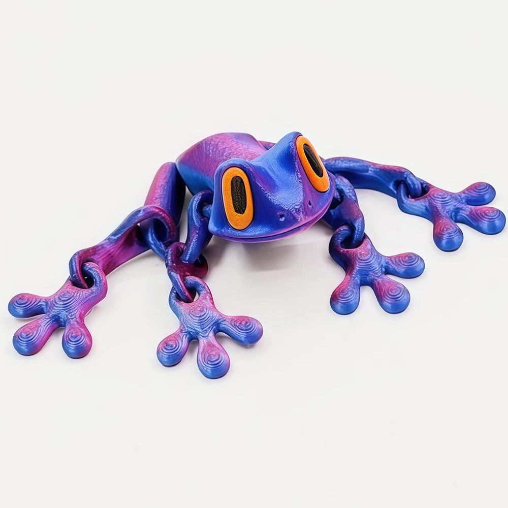 A realistic, movable 3D printed frog fridge magnet in purple and blue tones.