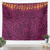 A vibrant pink and black leopard print tapestry wall hanging with warm string lights.