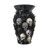 A black decorative vase shaped like a cluster of skulls made from resin.