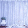 White LED curtain string lights illuminating a soft blue fabric backdrop with white accents and a dove-shaped decoration.