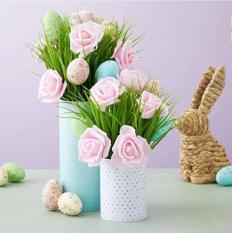 A bouquet of pink and green artificial foam roses and small eggs in a light blue vase