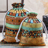 A close-up of a vintage cotton drawstring gift pouch with multicolored geometric embroidery.