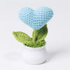 Hand woven light blue heart flower in a green pot