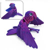 A purple articulated 3D printed parrot figurine with movable wings shown in detail and full view.