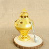 A gold-plated Orthodox censer with bells resting on a wooden slice.