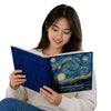 A woman holds open a blue laminated photo album titled Cherished Moments