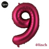 A large, shiny magenta foil number balloon shaped like the number 9.