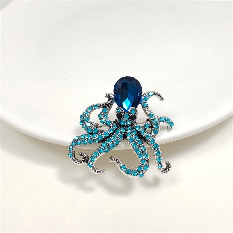 A vintage marine life brooch pin set featuring a sapphire blue octopus design with sparkling blue and silver accents.