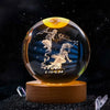 A spherical crystal ball with a dark background featuring a silver silhouette of a leaping figure and the date 2.19.3.20 on a