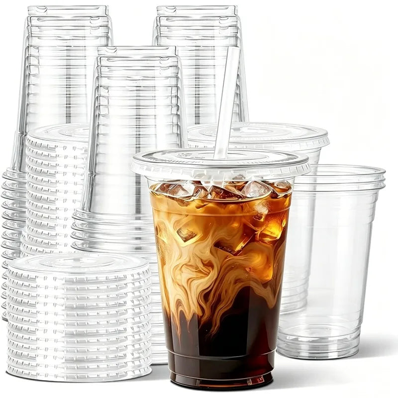 A stack of clear disposable plastic cups with lids and a glass of iced coffee