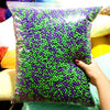 A bag filled with purple foam beads for crafting and decoration, held by a hand.