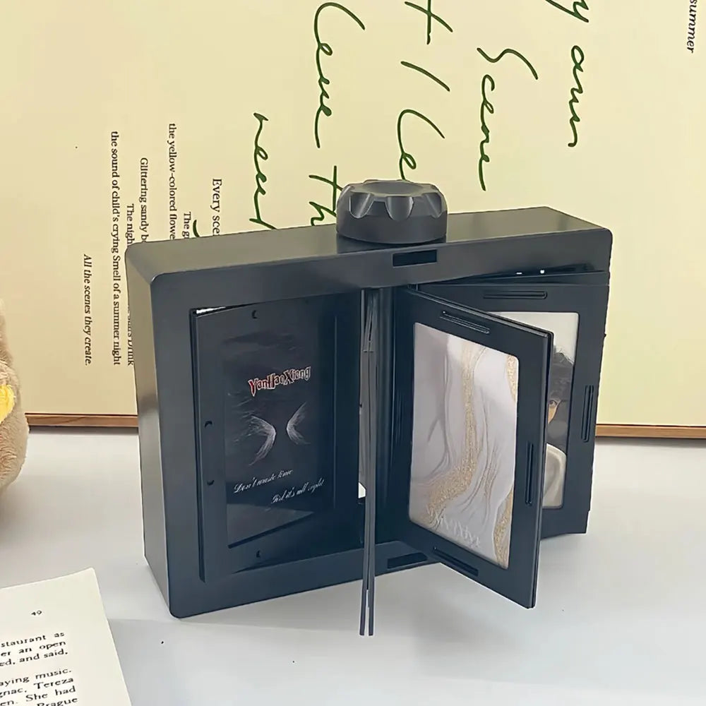 A black rotating flip photocard display frame is shown on a white surface.