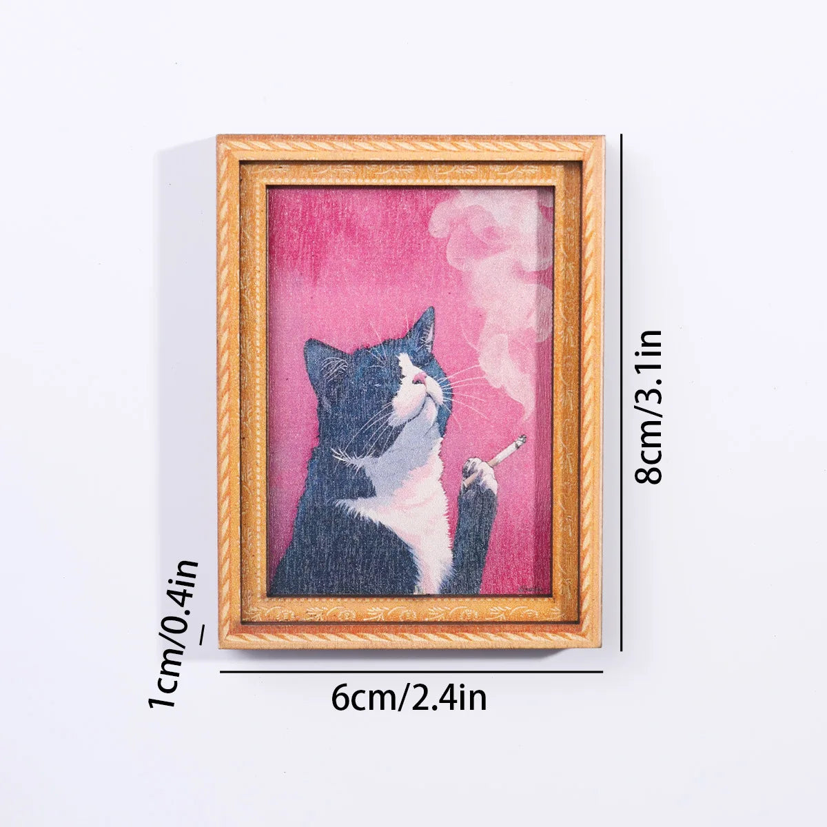 A framed artwork featuring a black and white cat silhouette against a pink background.